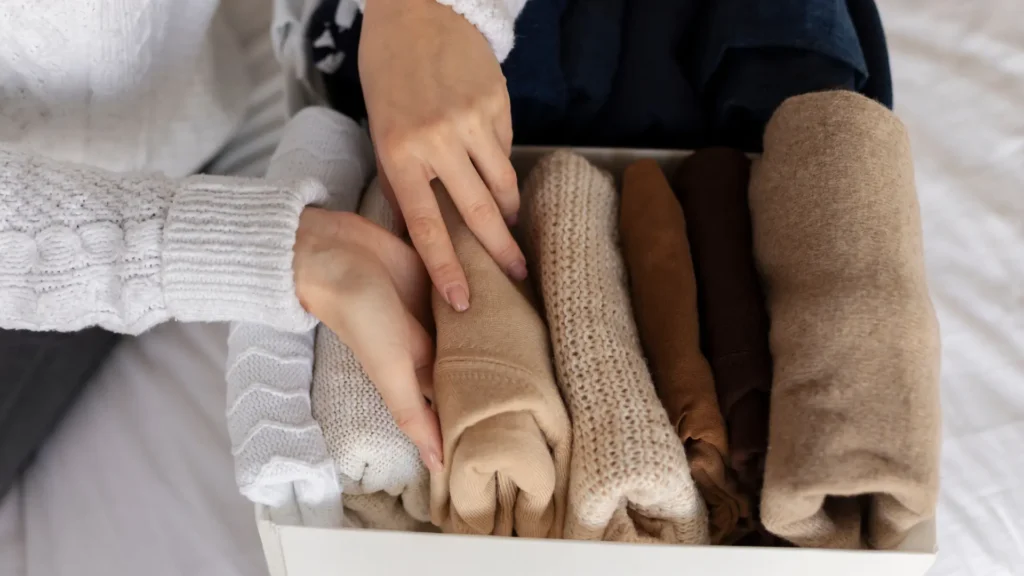 wanita merapikan berbagai pakaiannya dalam capsule wardrobe
