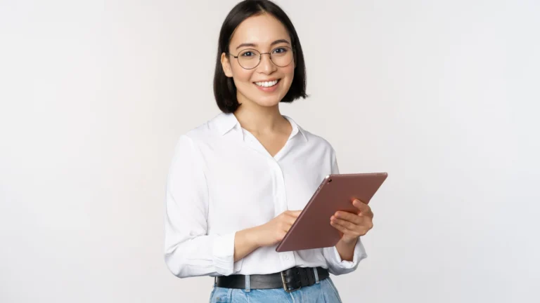 seorang wanita dengan tablet menggunakan smart casual outfit mencakup kemeja putih dan celana jeans